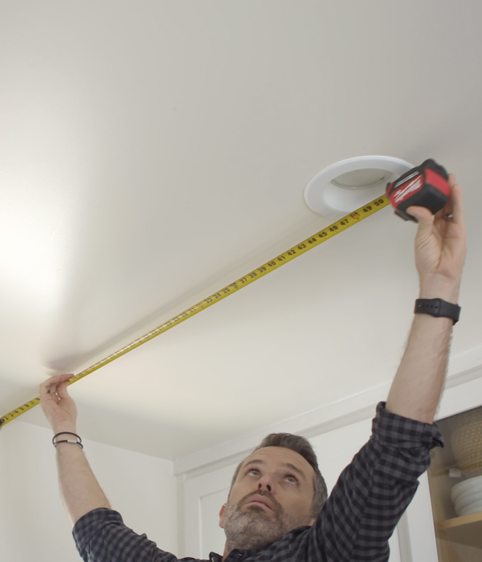 Measuring to the center of a recessed ceiling light with a tape measure